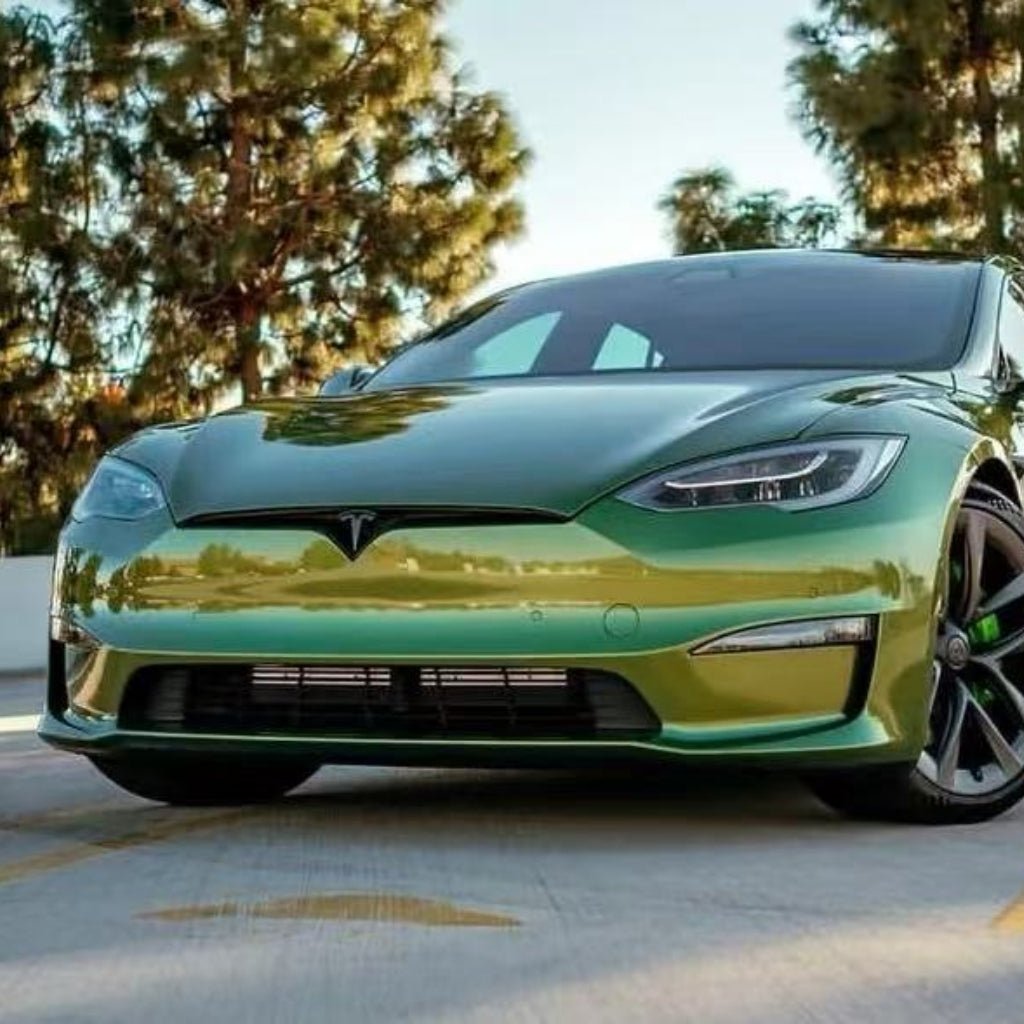 A green Tesla Model S is parked outdoors on a sunny day with trees behind it, protected by Blue Gold Green Chameleon SelfRepair Nano-Coated PPF for účinná ochrana karosérie and samoliečivá nano technológia.