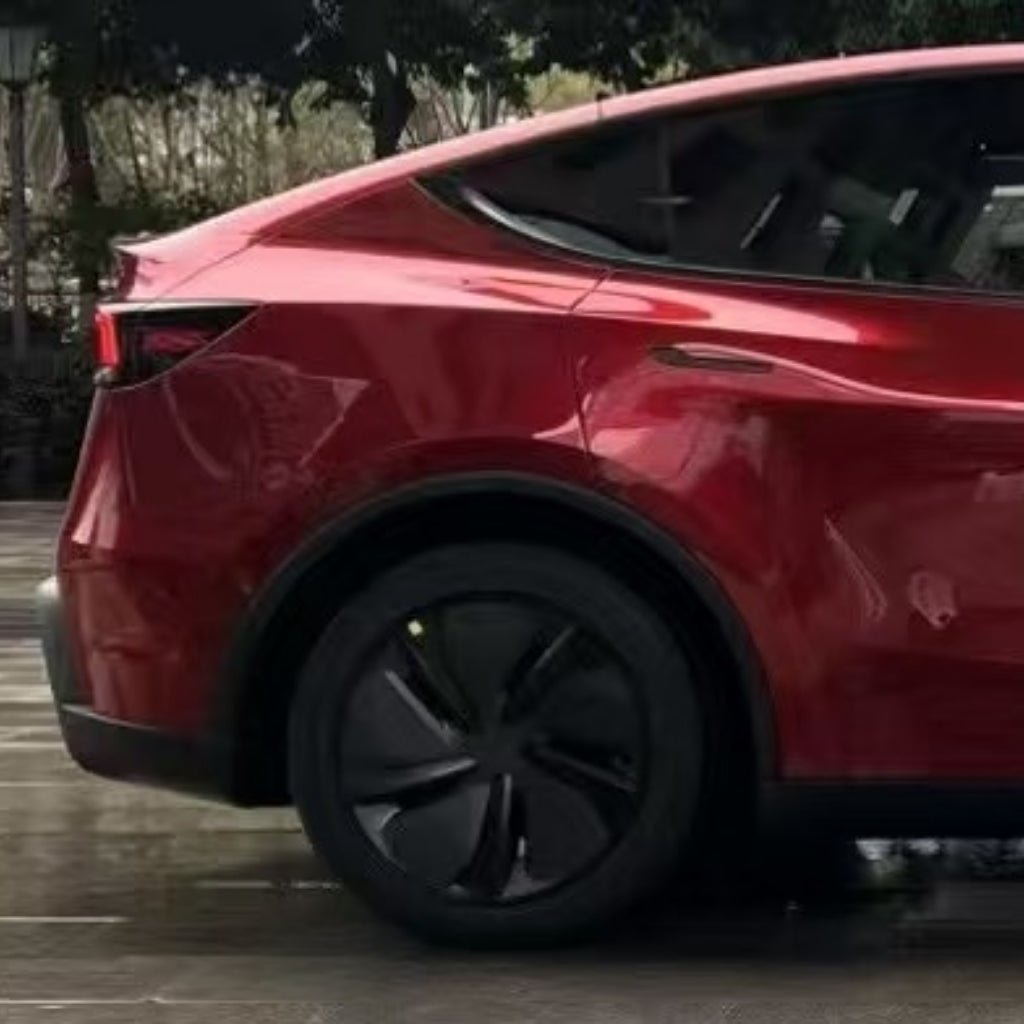 Close-up of the rear side of a shiny red electric car protected with Fire Red Laser SelfRepair Nano-Coated PPF, showing the back wheel, taillight, and rear window. The self-healing film has nano technology and a blurred background of trees and pavement.