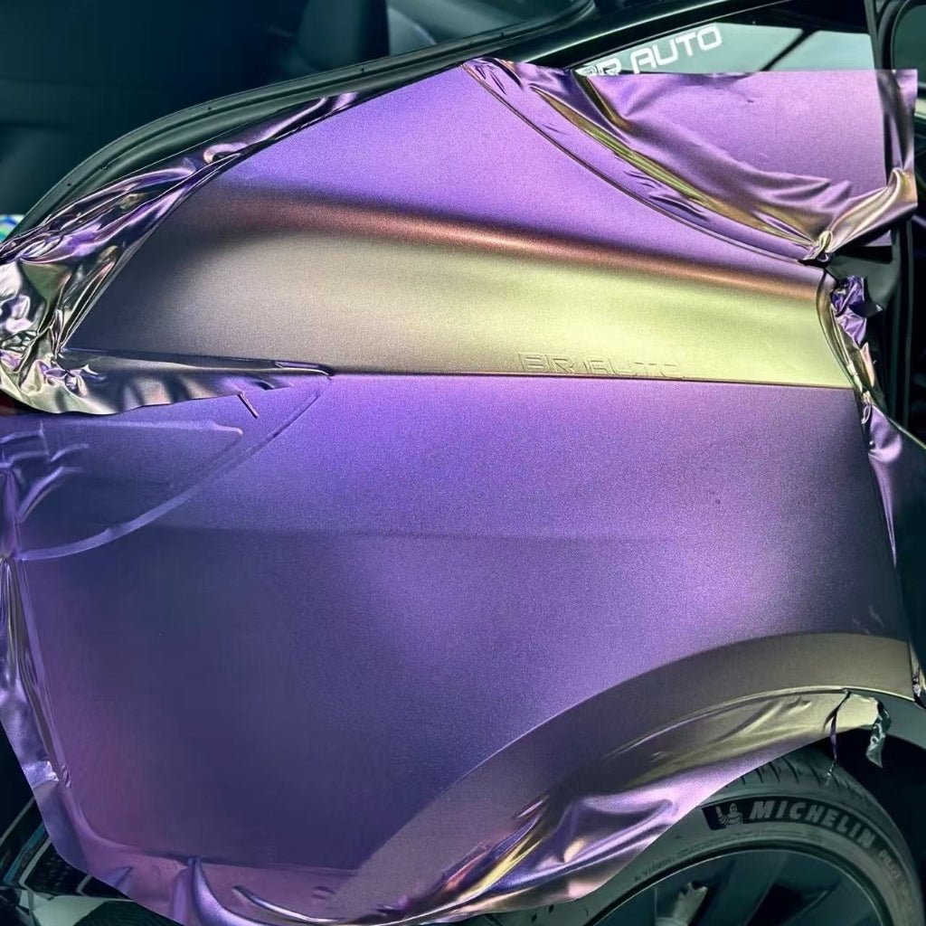 A car’s rear quarter panel is partially wrapped in Gold Red Purple Chameleon SelfRepair Nano-Coated PPF, revealing an iridescent effect. The half-applied, wrinkled film sits above a tire featuring the Michelin brand.