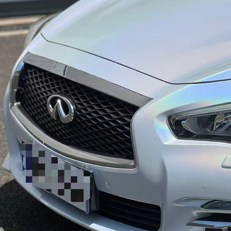 Close-up of the front grille and headlights of a silver Infiniti car, featuring White Galaxy Glossy SelfRepair Nano-Coated PPF for body protection, with a blurred license plate.