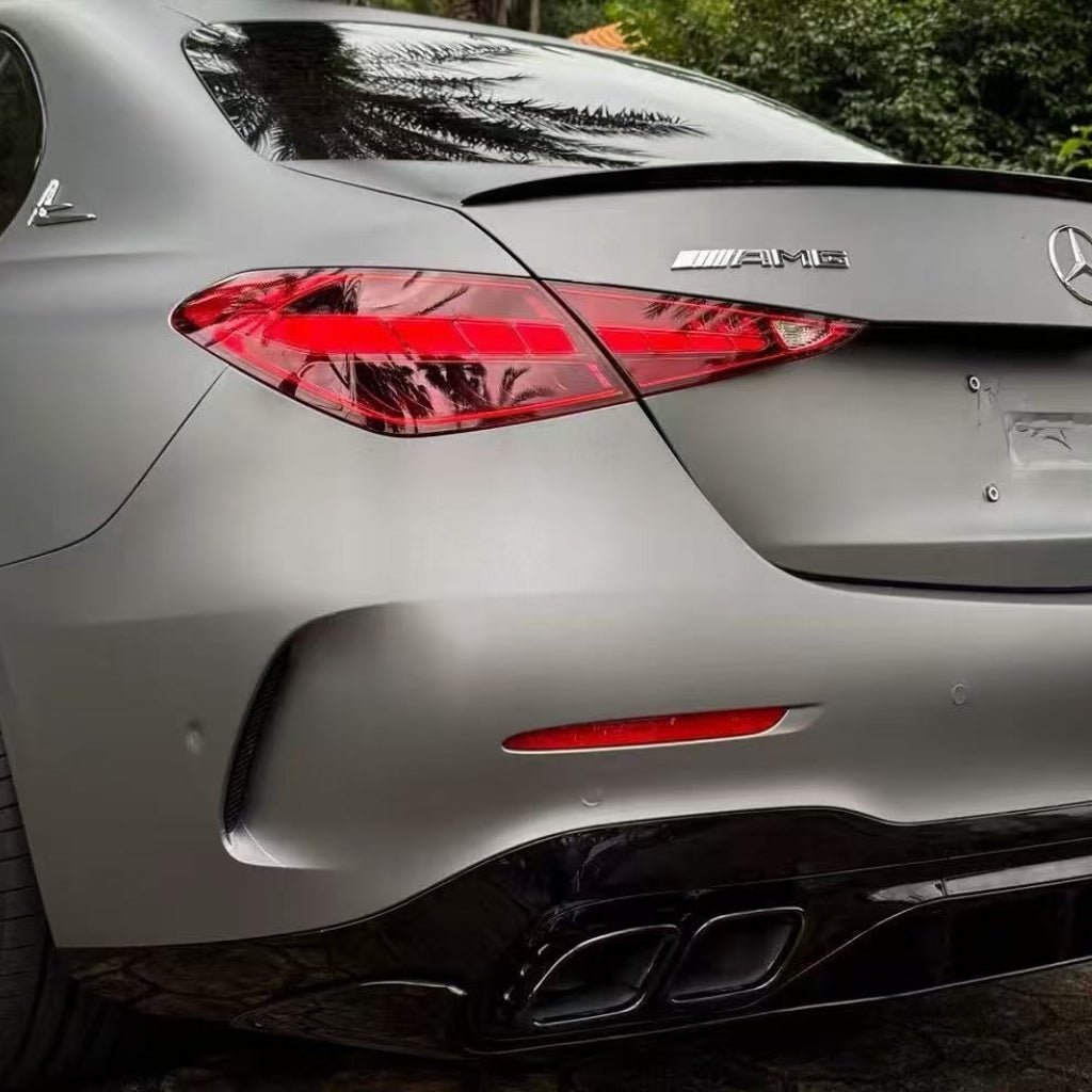 Rear view of a matte grey Mercedes-Benz AMG parked outdoors with AMG and Mercedes badges, black rear diffuser, dual exhaust pipes, and its surface protected by AMG Mountain Gray Matte SelfRepair Nano-Coated PPF.