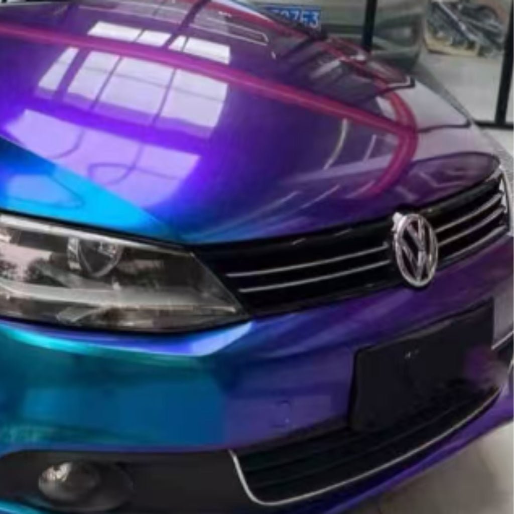 A Volkswagen with a Purple Blue Green Chameleon SelfRepair Nano-Coated PPF wrap is parked indoors; its hood and front grill are visible, shielded by this advanced protective film.