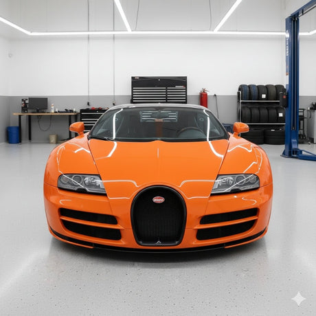 An orange Bugatti sports car with Diamond Racing Orange Glossy SelfRepair Nano-Coated Nexthor™ PPF is parked in a pristine, modern garage featuring light gray floors, wall-mounted tools, stacked tires, and an automotive lift in the background.