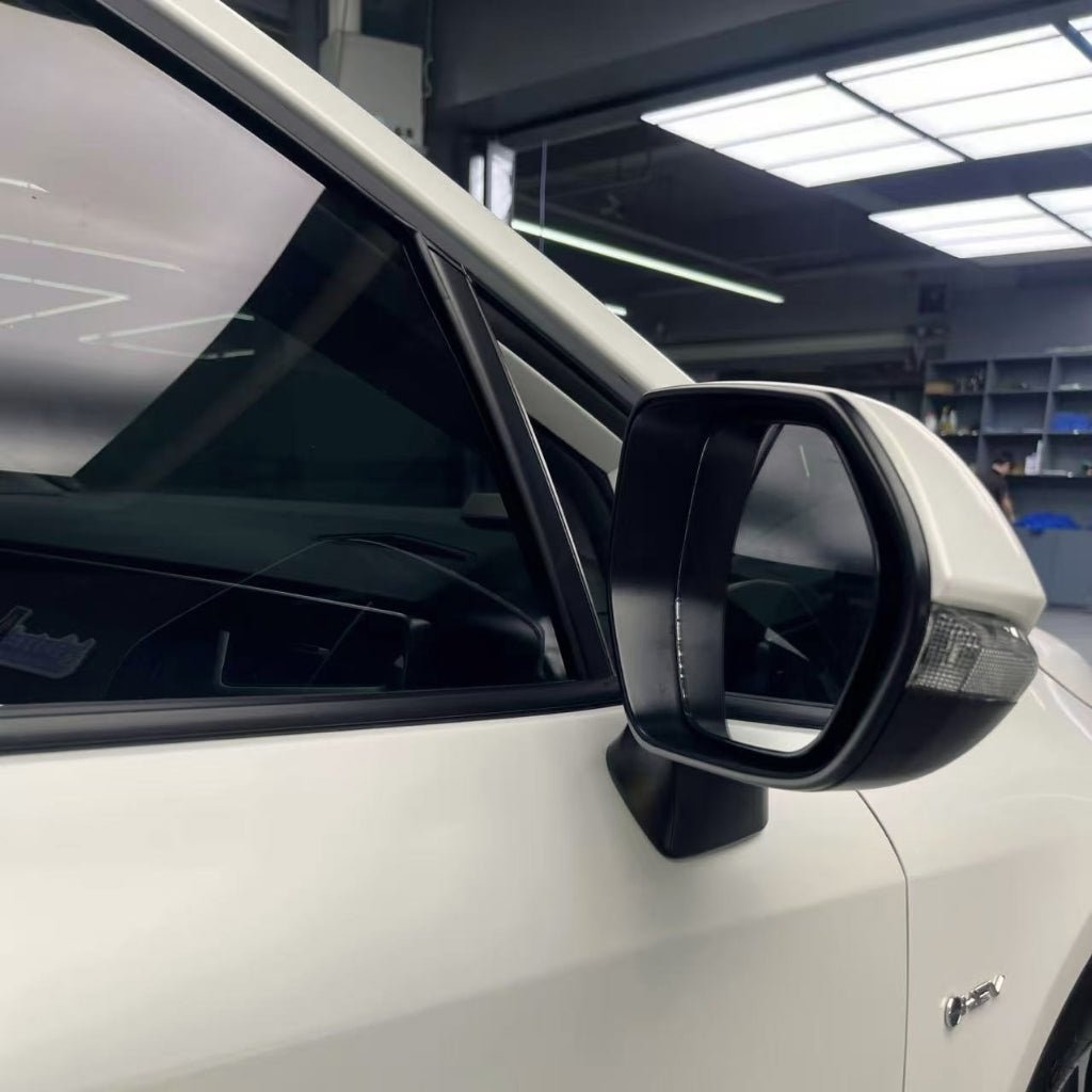 Close-up of a white car’s side mirror and front window in a modern garage with bright ceiling lights—featuring Satin Liquid Metallic Bronze SelfRepair Nano-Coated PPF for lasting clarity and advanced protection.