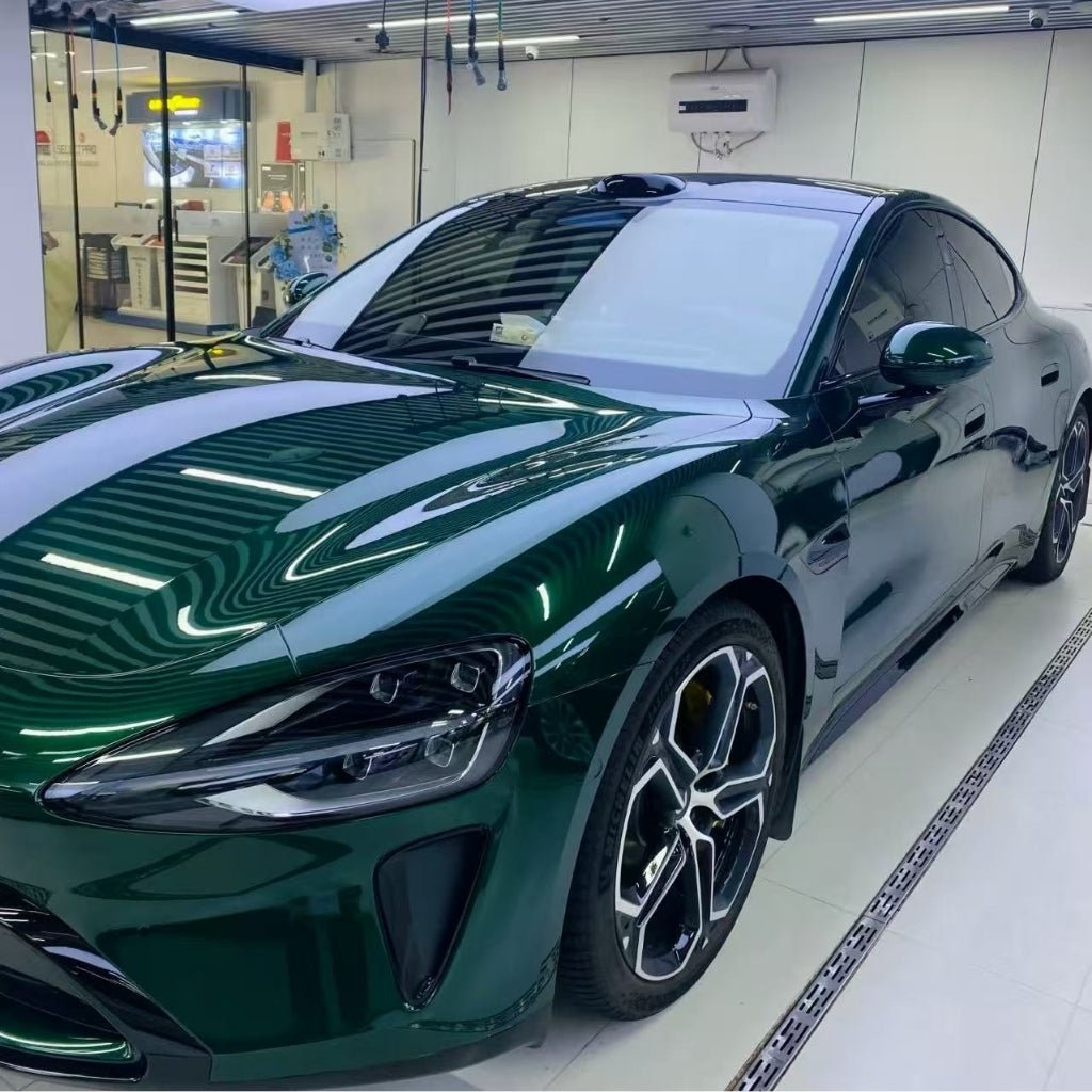 A sleek luxury sports car in Agate Green Liquid Metallic Glossy SelfRepair Nano-Coated PPF is parked inside a modern garage with white walls and a reflective floor.