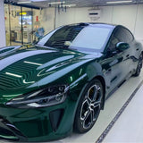 A sleek luxury sports car in Agate Green Liquid Metallic Glossy SelfRepair Nano-Coated PPF is parked inside a modern garage with white walls and a reflective floor.