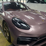 A rose gold Porsche sports car, protected by Ice Berry Pink Liquid Metallic Glossy SelfRepair Nano-Coated PPF, is parked indoors beside a white SUV. Window reflections highlight the car's glossy nano-coated PPF film finish.