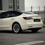 A white Tesla Model 3 with a VIP plate, protected by Pepper White Glossy SelfRepair Nano-Coated PPF, is parked in a lot with a modern building and fencing visible in the background.