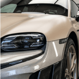 Close-up of a luxury sports car’s front left side, showcasing a sleek headlight, metallic champagne paint, and carbon fiber accents protected by Liquid Metallic Aluminium Carbon Fiber Self-Healing Nano-Coated PPF under indoor natural light.