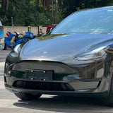 A close-up of a black Tesla’s front, highlighting the headlight, hood, grille, and license plate area protected by Diamond Black Gold Glossy SelfRepair Nano-Coated Nexthor™ PPF.