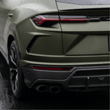 Close-up of a matte green luxury SUV with Matte Carbon Fiber SelfRepair Nano-Coated PPF, showing raindrops on the surface, modern tail lights, dual exhausts, and black trim glistening on wet pavement.
