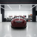 A burgundy Rolls-Royce, shielded by Diamond Black Rose Glossy SelfRepair Nano-Coated PPF, stands in a sleek, modern garage with tool cabinets and shelves, reflecting a premium, organized professional vibe.