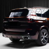 A BMW X5 SUV with Magic Black to Red Charm Glossy SelfRepair Nano-Coated PPF is parked indoors, viewed from the rear left. The surface reflects indoor lighting, accentuating its modern taillights and dual exhausts.