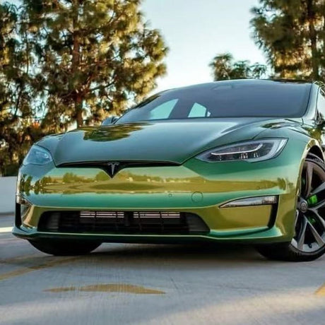 A green Tesla Model S is parked outdoors on a sunny day with trees behind it, protected by Blue Gold Green Chameleon SelfRepair Nano-Coated PPF for účinná ochrana karosérie and samoliečivá nano technológia.