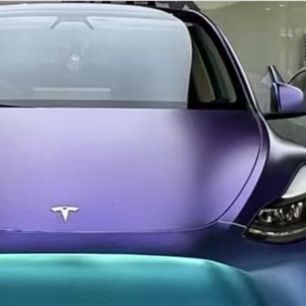 Front view of a purple Tesla with Chameleon Purple Blue Green Matte SelfRepair Nano-Coated PPF on the hood, windshield, and headlights, featuring a chrome Tesla logo centered on the hood.