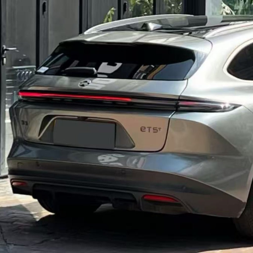 A silver NIO ET5 is parked outdoors, viewed from the rear with a single-strip taillight. Its modern design shines, protected by Chrome Black Liquid Metallic Glossy SelfRepair Nano-Coated PPF and self-healing nanotechnology.