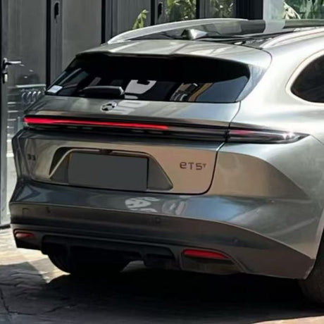 A silver NIO ET5 is parked outdoors, viewed from the rear with a single-strip taillight. Its modern design shines, protected by Chrome Black Liquid Metallic Glossy SelfRepair Nano-Coated PPF and self-healing nanotechnology.