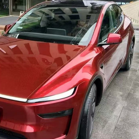 A shiny red electric car, protected by Fire Red Laser SelfRepair Nano-Coated PPF, is parked near a building. Its sleek, glossy exterior reflects its surroundings and benefits from advanced self-healing nano technology.