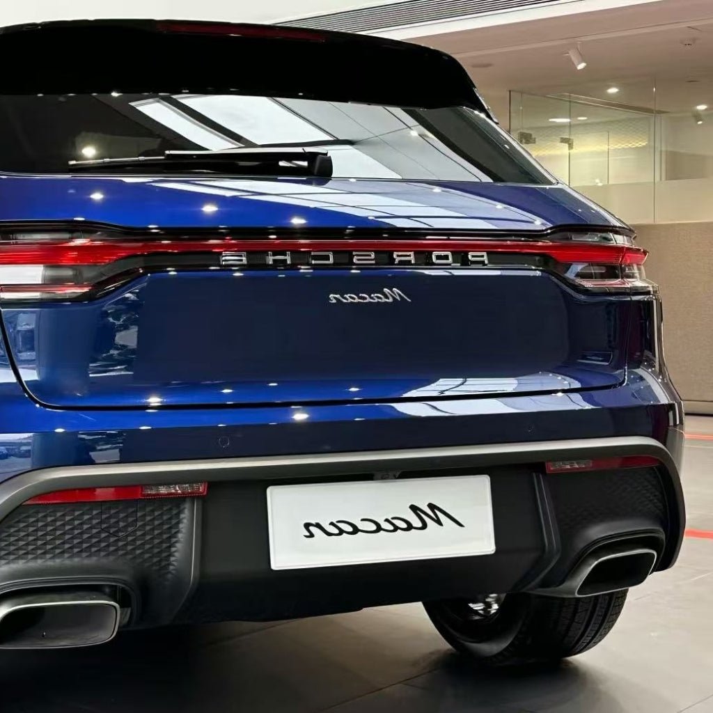 Rear view of a blue Porsche Macan SUV in a showroom with tail lights, rear badge, and dual exhaust pipes. Protected by Diamond Gentian Blue Glossy SelfRepair Nano-Coated PPF for advanced paint protection.