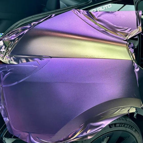 A car’s rear quarter panel is partially wrapped in Gold Red Purple Chameleon SelfRepair Nano-Coated PPF, revealing an iridescent effect. The half-applied, wrinkled film sits above a tire featuring the Michelin brand.