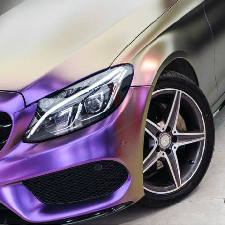 Close-up of the front left side of a luxury car featuring Gold Red Purple Chameleon SelfRepair Nano-Coated PPF, shifting between gold, red, and purple with a modern headlight and five-spoke alloy wheel for a standout color effect.