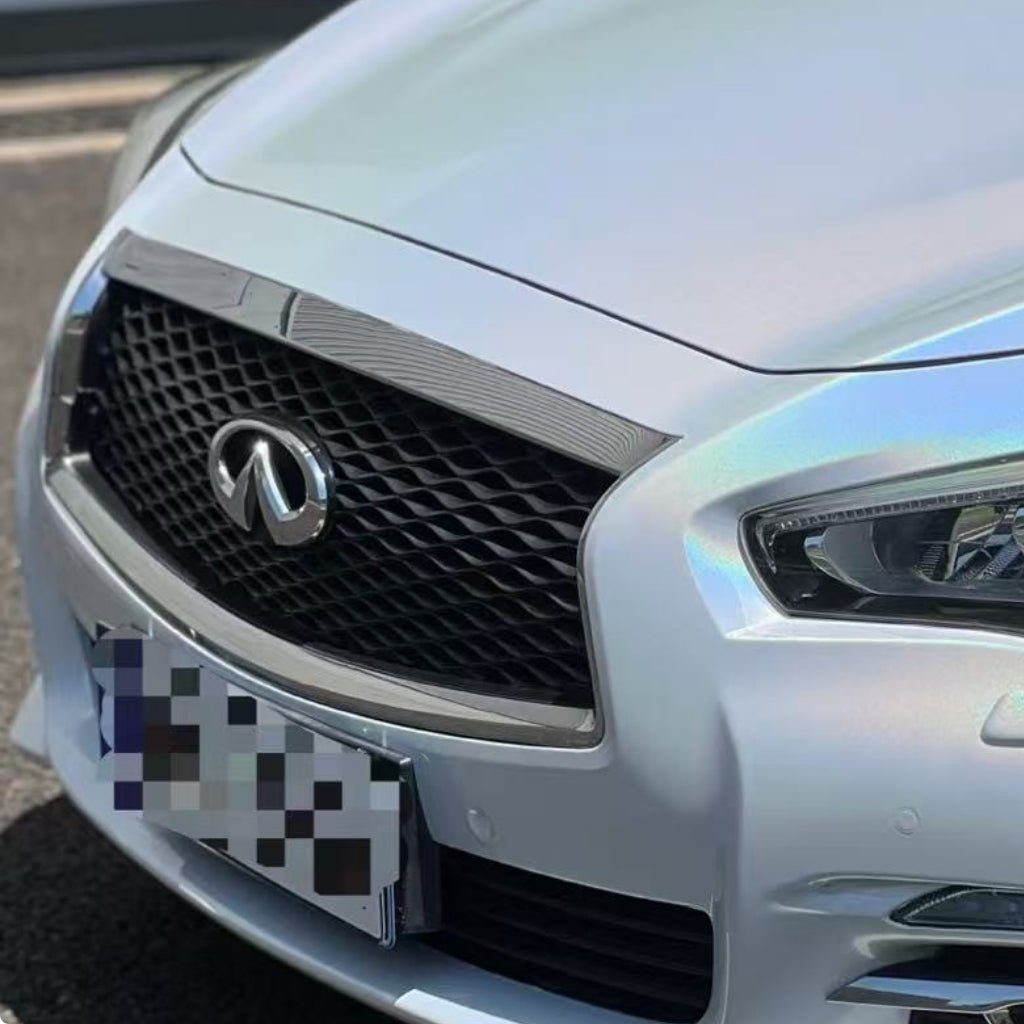 Close-up of the front grille and headlights of a silver Infiniti car, featuring White Galaxy Glossy SelfRepair Nano-Coated PPF for body protection, with a blurred license plate.
