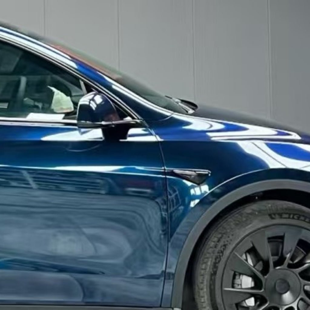 A close-up side view of a dark blue car, highlighting the front wheel, side mirror, and door with reflections on the shiny surface protected by Mystic Blue Glossy SelfRepair Nano-Coated PPF for advanced vehicle paint protection.