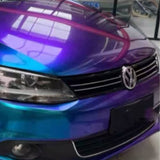 A Volkswagen with a Purple Blue Green Chameleon SelfRepair Nano-Coated PPF wrap is parked indoors; its hood and front grill are visible, shielded by this advanced protective film.