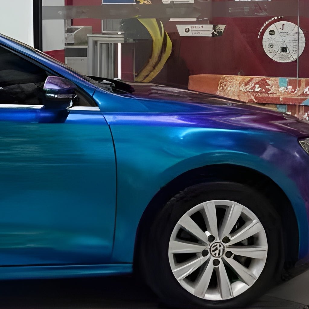 A shiny car with Purple Blue Green Chameleon SelfRepair Nano-Coated PPF is parked indoors, showcasing its front and wheel. Behind it, a colorful mural with a banana, text, and graphics adds vibrant flair.