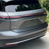The rear view of a gray Nio ES6 electric SUV parked near greenery, featuring taillights spanning the back and an es6 badge on the left, protected by Silver Liquid Metallic Matte SelfRepair Nano-Coated PPF for karoséria protection.