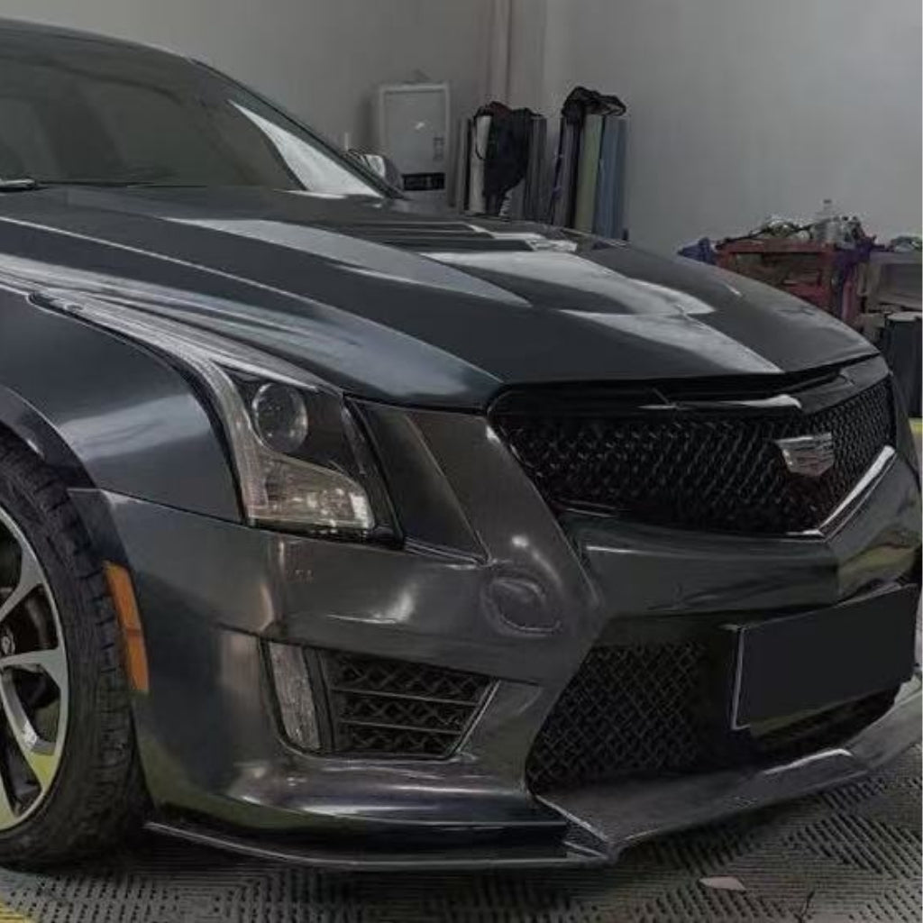 A close-up of the front left side of a dark gray Cadillac in a garage, showcasing its headlight, Cadillac grille, sleek lines, and Sparkle Black Matte SelfRepair Nano-Coated Nexthor™ for superior protection.