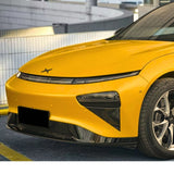 A close-up of a car front wrapped in Racing Yellow Glossy SelfRepair Nano-Coated PPF, featuring a sleek hood, sharp headlights, and a bold black emblem, parked in an urban setting.