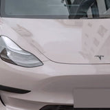 Close-up of a light-colored Tesla’s front with headlight, hood logo, and windshield—upgraded by Sky Mirror Pink Glossy SelfRepair Nano-Coated PPF for standout looks and extra ochranná fólia na auto protection.