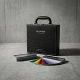 A Nexthor PPF Sample Kit (All Colors) in a textured black case sits on a gray surface, with two fan-shaped color sample booklets displaying a variety of colors spread out in front.